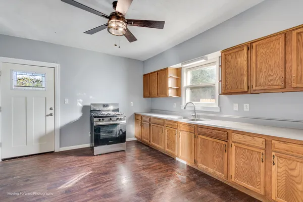 a kitchen with granite countertop a stove cabinets and wooden floor