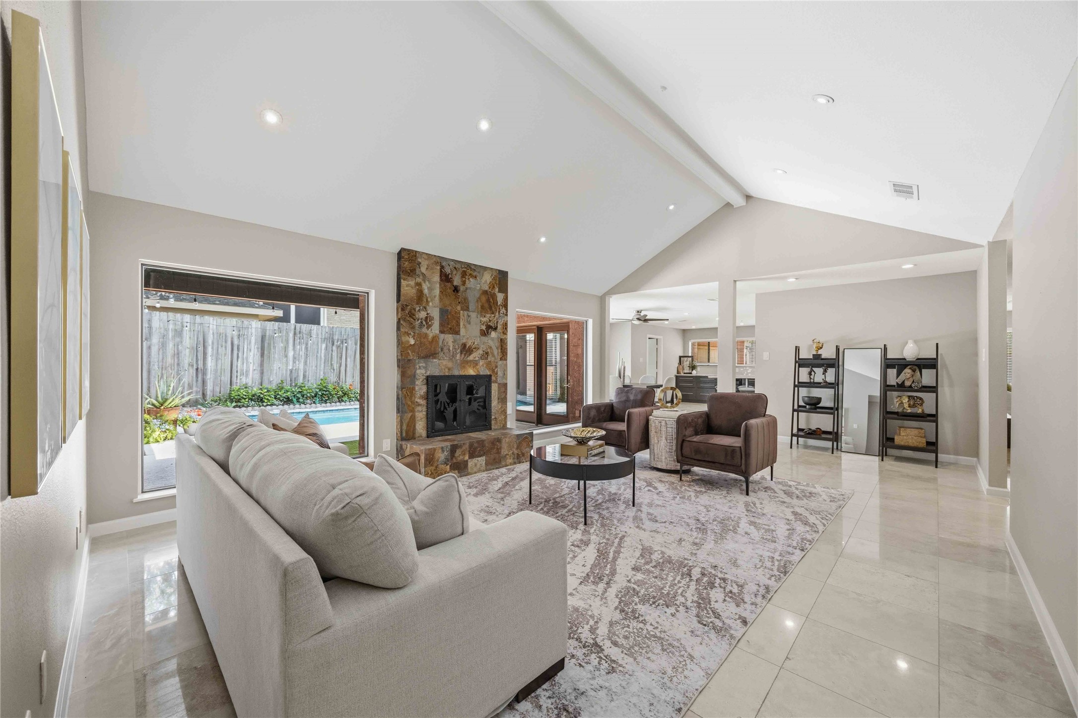 619 Rancho Bauer Drive Houston, TX 77079 - Photo 9 of 46 An inviting first impression begins with soaring vaulted ceilings, expansive windows framing sparkling pool views, and a dramatic floor-to-ceiling stone fireplace that instantly makes you feel at home.