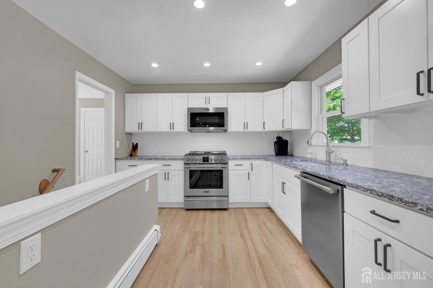 205 Hockenbury Road Hillsborough, NJ 08844 - Photo 13 of 38 a kitchen with granite countertop a stove top oven sink and cabinets