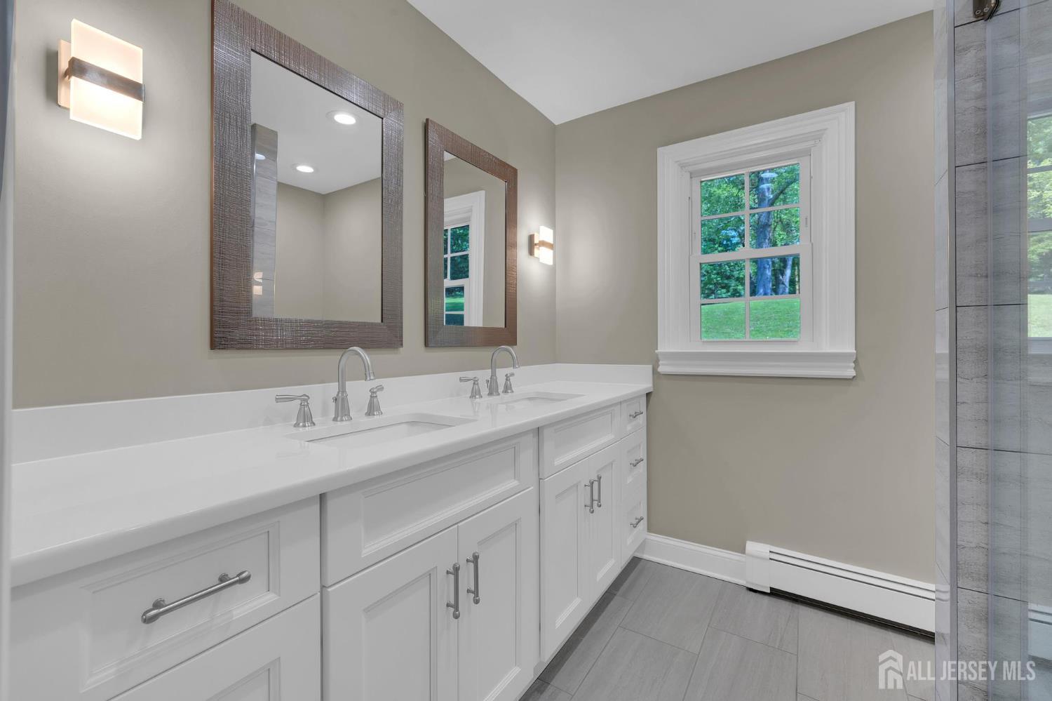 205 Hockenbury Road Hillsborough, NJ 08844 - Photo 19 of 38 a bathroom with a double vanity sink and a mirror
