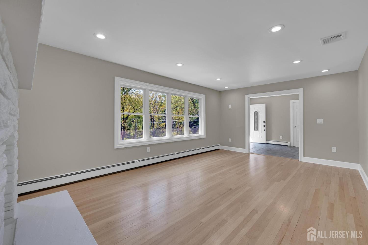 205 Hockenbury Road Hillsborough, NJ 08844 - Photo 9 of 38 an empty room with wooden floor and windows