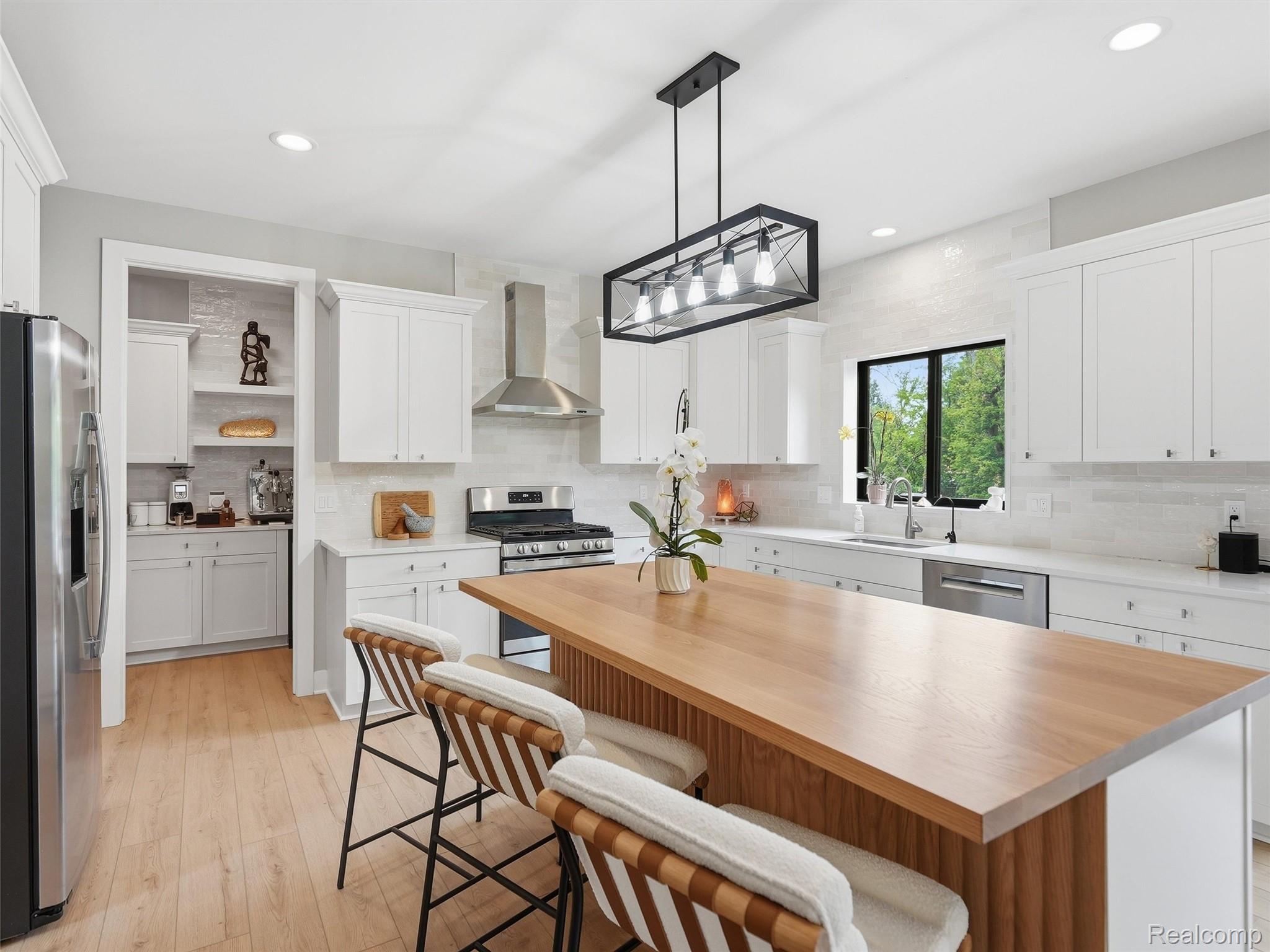 3007 28 Mile Road Washington, MI 48094 - Photo 12 of 69 Contemporary kitchen featuring a large wood-finish island, stainless steel appliances, recessed lighting, and a white subway tile backsplash