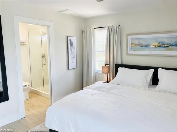 a bedroom with a bed and painting on the wall