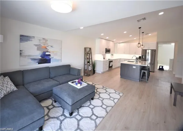 a living room with furniture kitchen view and a dining table