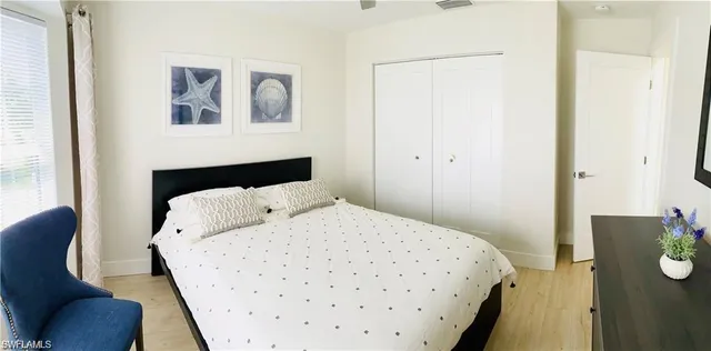 a bedroom with a bed and painting on the wall