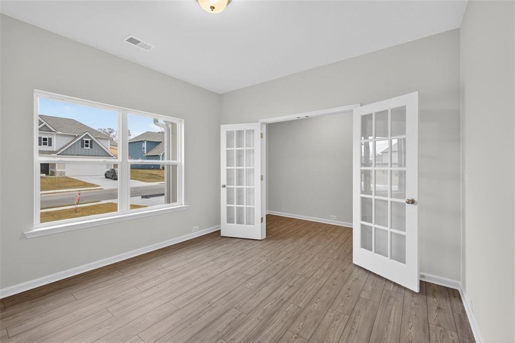 303 Roxeywood Way Winder, GA 30680 - Photo 2 of 47 an empty room with wooden floor and windows