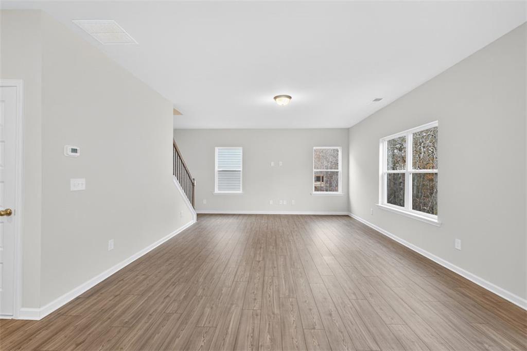 303 Roxeywood Way Winder, GA 30680 - Photo 5 of 47 a view of an empty room with wooden floor and windows