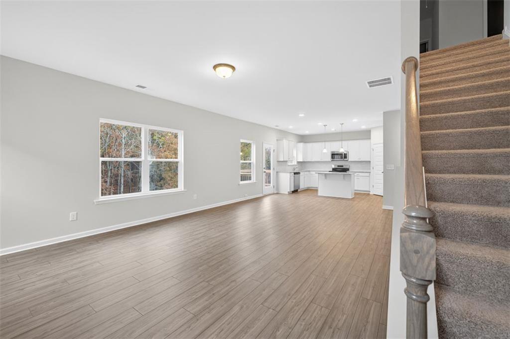 303 Roxeywood Way Winder, GA 30680 - Photo 8 of 47 a view of empty room with wooden floor and windows