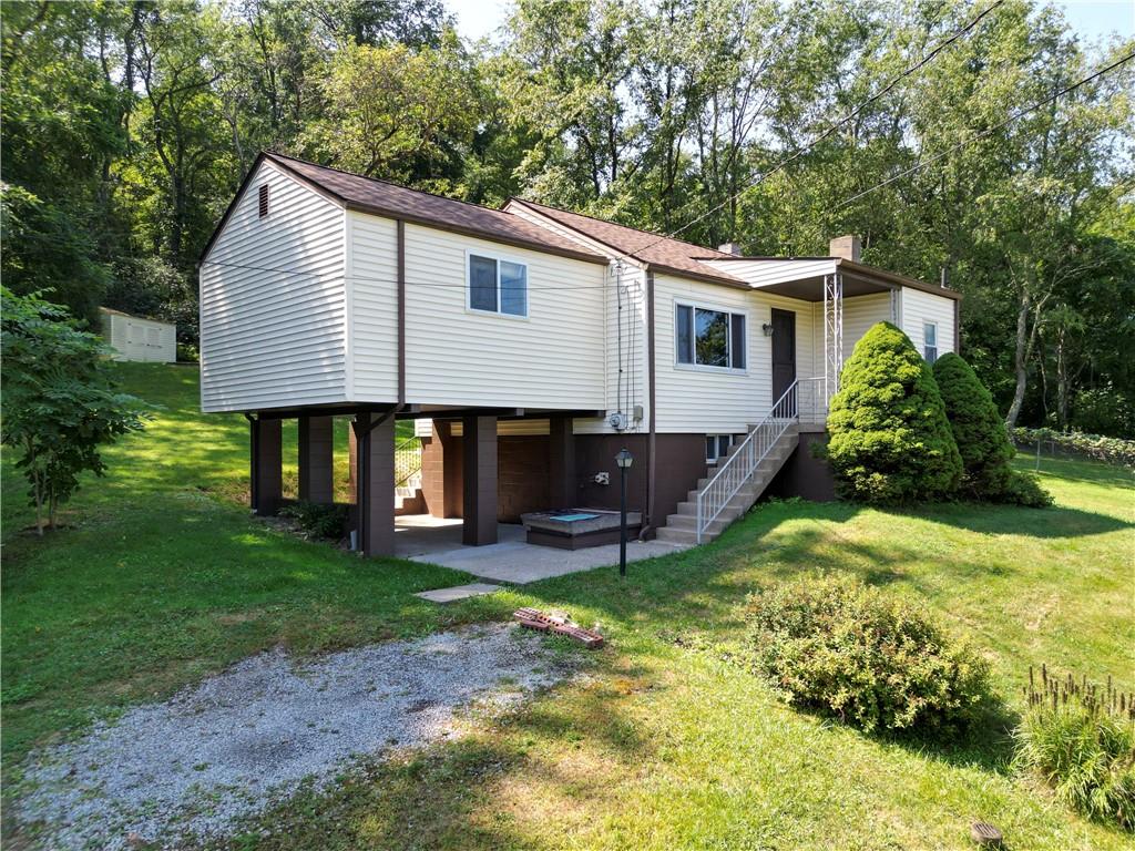 a view of a house with a yard and sitting area