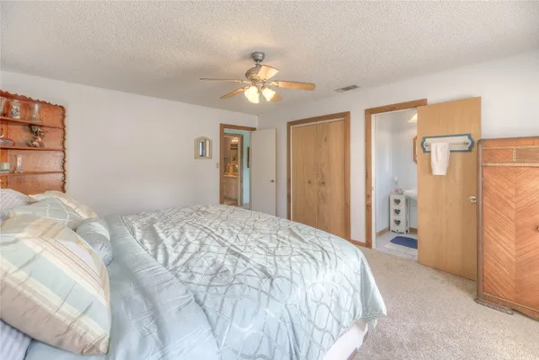 a spacious bedroom with a bed and a chandelier
