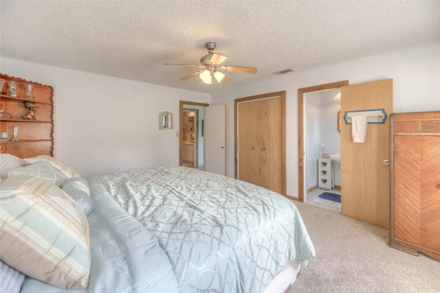 a spacious bedroom with a bed and a chandelier