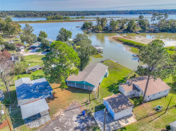an aerial view of residential houses with outdoor space and lakeside