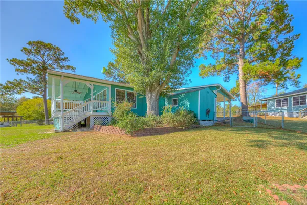 a view of a house with a big yard and potted plants