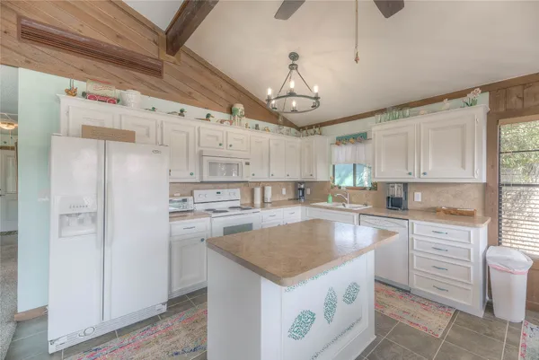 a kitchen with a center island a counter space stainless steel appliances and cabinets