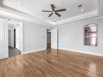 a view of an empty room with a window and wooden floor