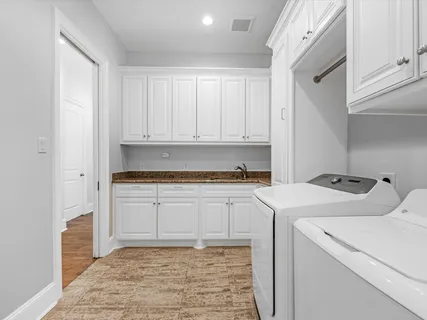 a kitchen with sink cabinets and utility room with washer and dryer