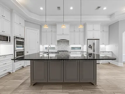 a kitchen with stainless steel appliances granite countertop a sink a stove and cabinets