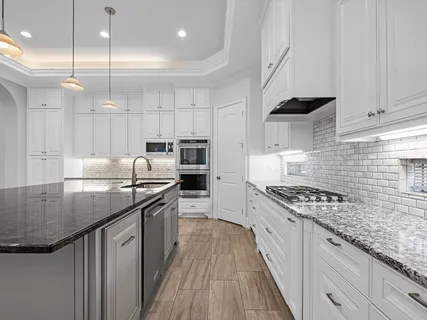 a kitchen with kitchen island stainless steel appliances a sink stove and cabinets