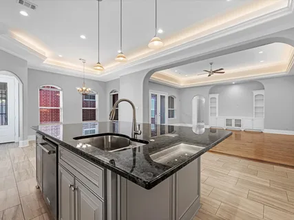 a kitchen with granite countertop a sink and chandelier