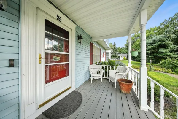 a balcony with wooden floor table and chairs