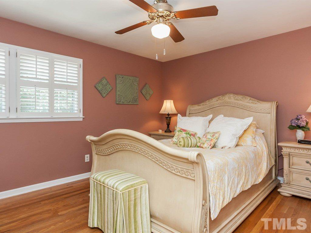 413 Crescent Court Raleigh, NC 27609 - Photo 16 of 25 a bedroom with a bed and a chandelier