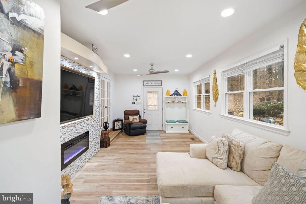 997 Mt Zion Marlboro Road Lothian, MD 20711 - Photo 25 of 58 a living room with furniture a fireplace and a flat screen tv