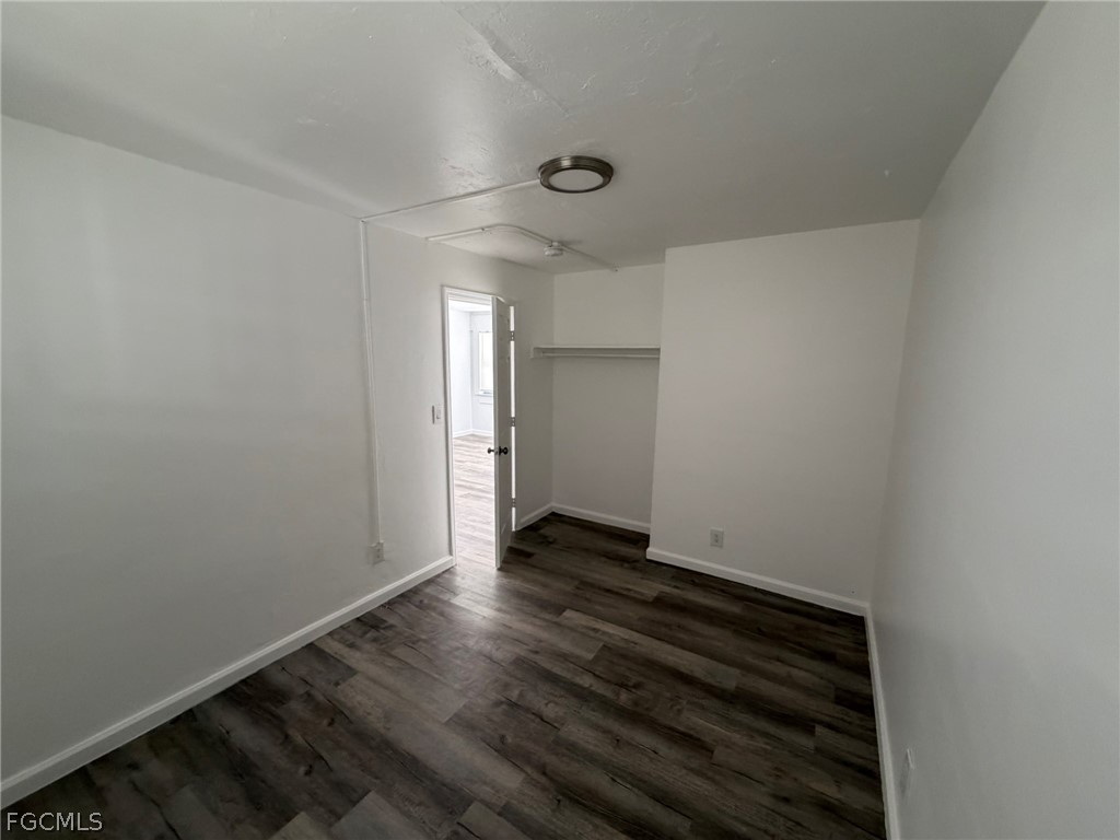 3033 2nd Street, Unit 2 Fort Myers, FL 33916 - Photo 7 of 9 a view of an empty room with wooden floor and a window