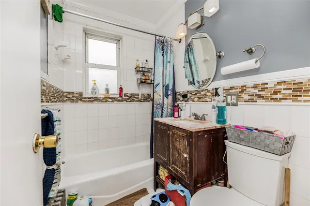 a bathroom with a sink vanity mirror bathtub and toilet