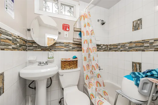 a bathroom with a sink toilet mirror and shower