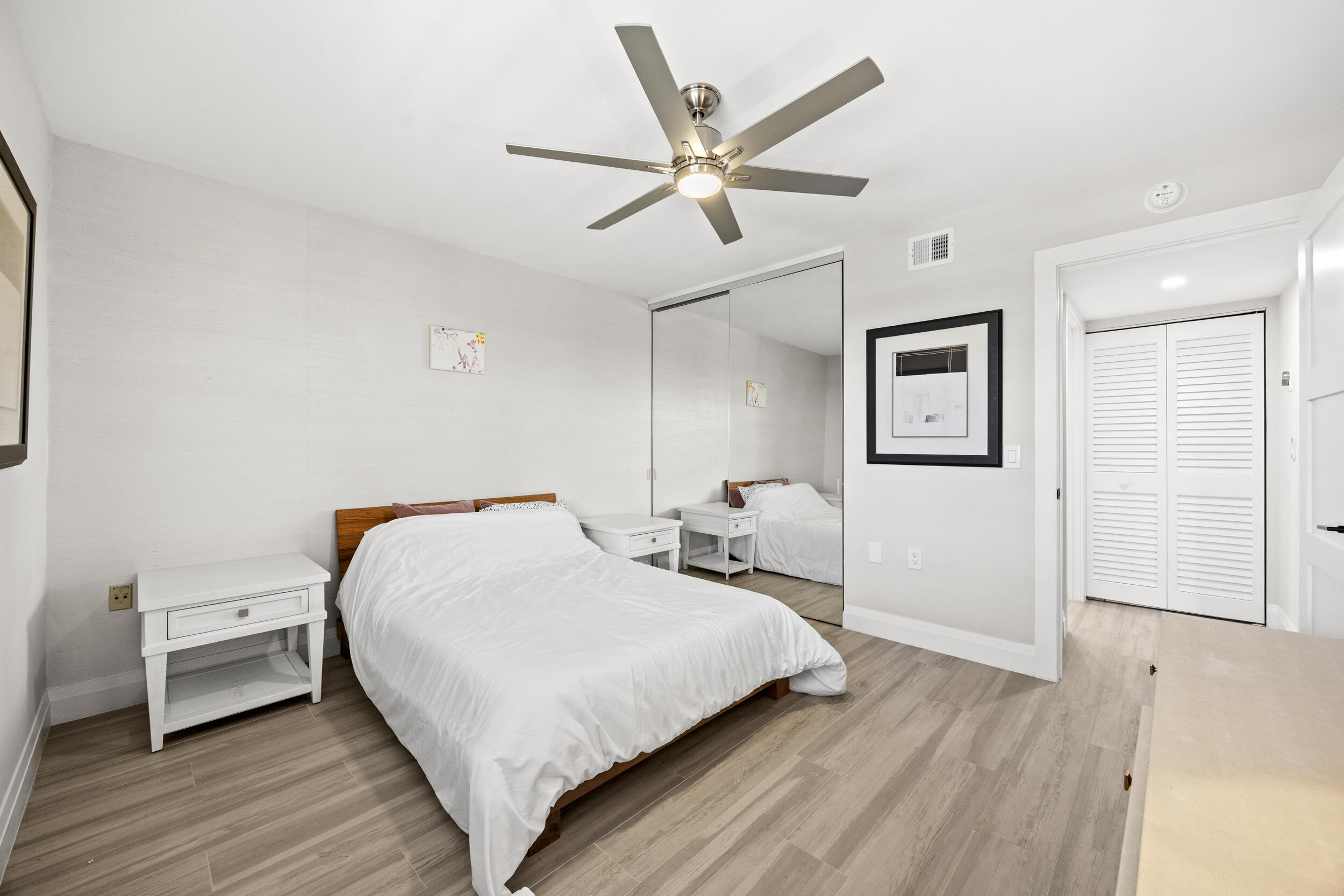 6061 Balboa Circle, Unit 403 Boca Raton, FL 33433 - Photo 29 of 44 a bedroom with a bed and wooden floor
