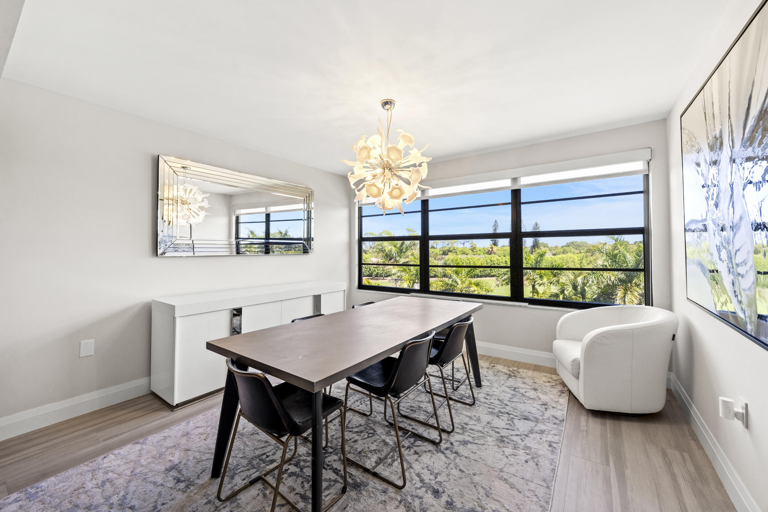 6061 Balboa Circle, Unit 403 Boca Raton, FL 33433 - Photo 3 of 44 a view of a dining room with furniture a chandelier and wooden floor