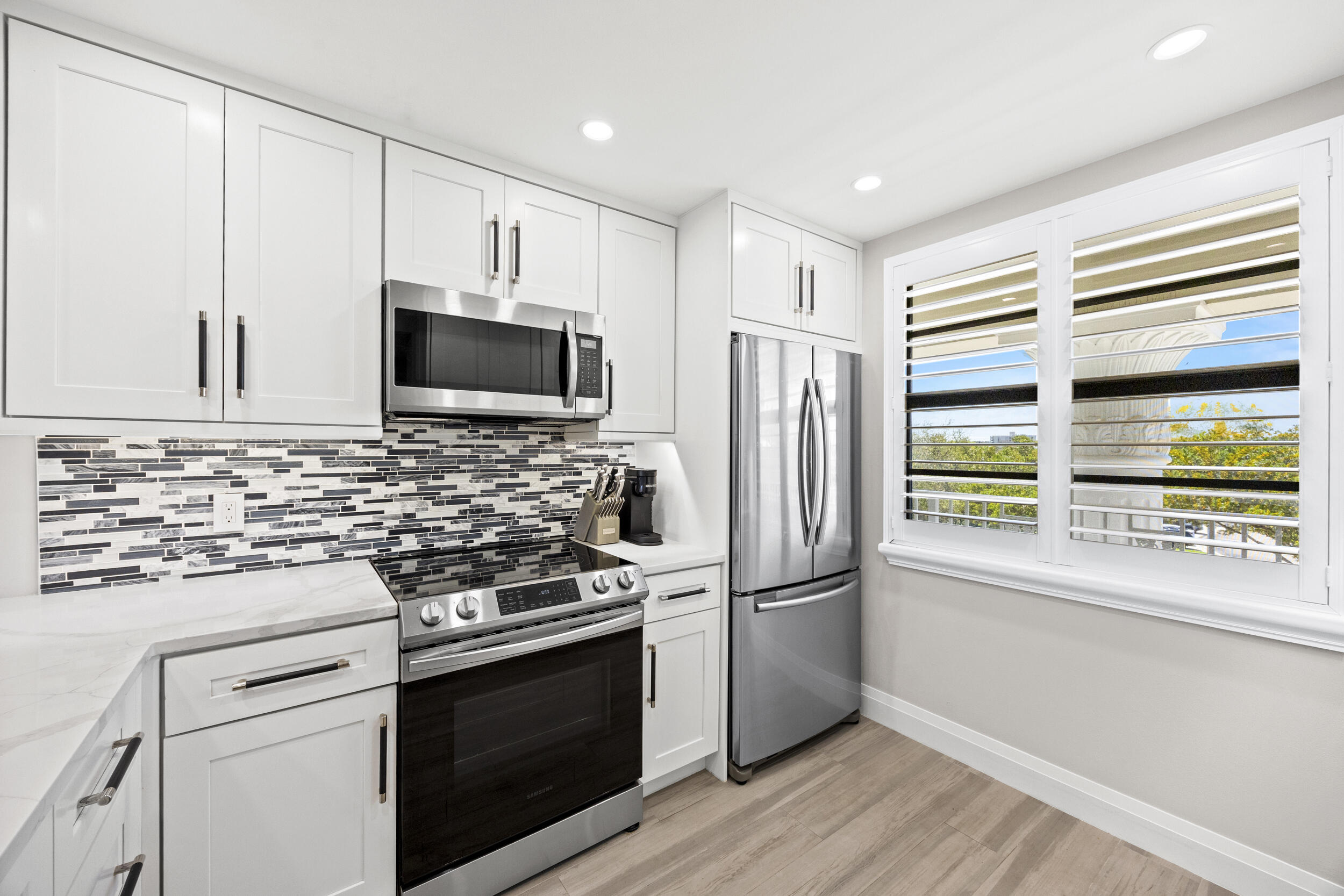 6061 Balboa Circle, Unit 403 Boca Raton, FL 33433 - Photo 8 of 44 a kitchen with stainless steel appliances a stove microwave and refrigerator