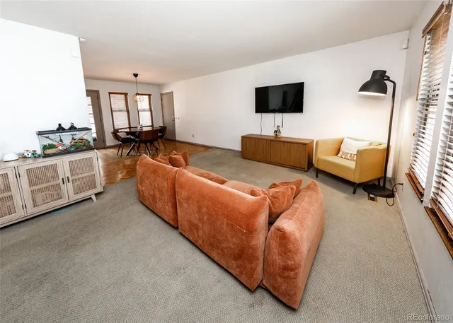 a living room with furniture a rug and a book shelf