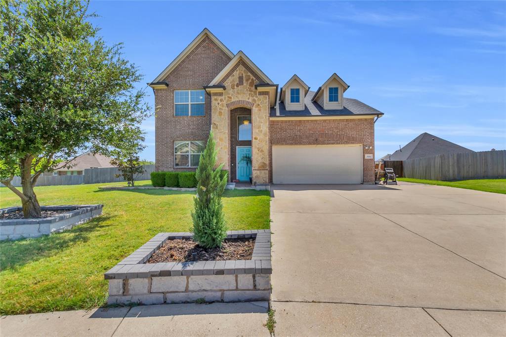 View of front of home with brick siding, concrete driveway, and a garage