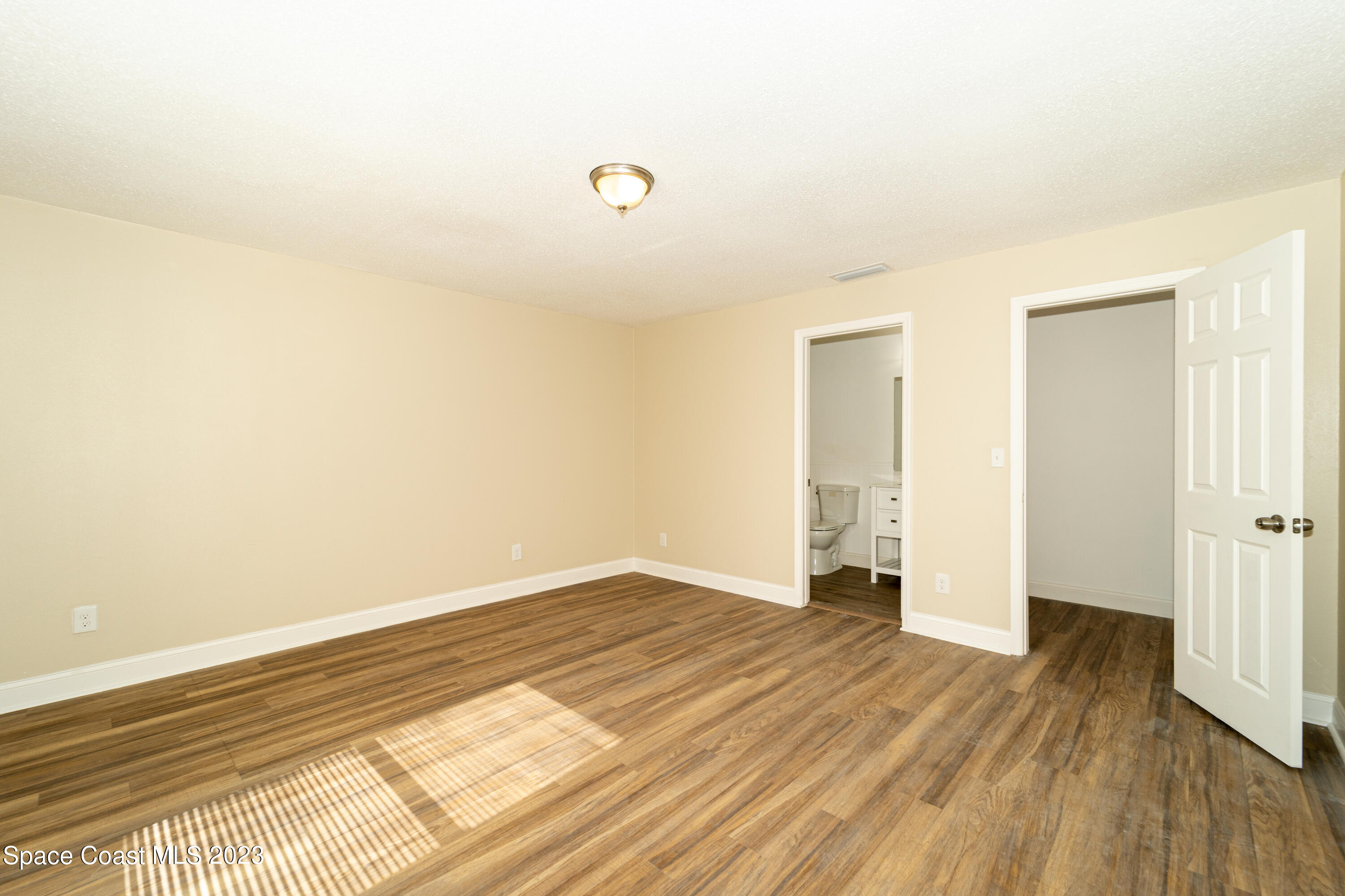 215 Trilby Road Southwest Palm Bay, FL 32908 - Photo 12 of 19 a view of an empty room and wooden floor