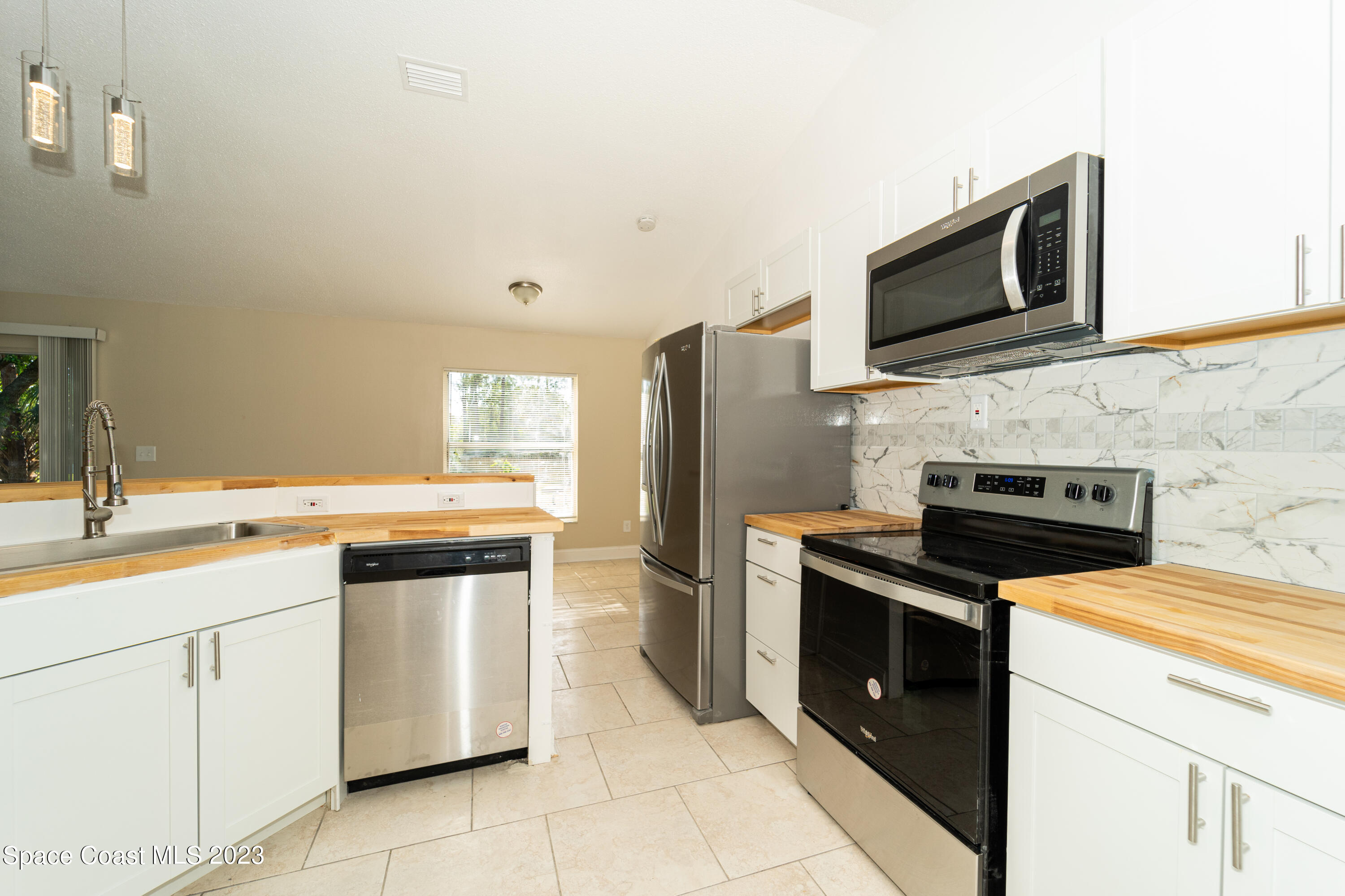 215 Trilby Road Southwest Palm Bay, FL 32908 - Photo 15 of 19 a kitchen with cabinets stainless steel appliances and sink