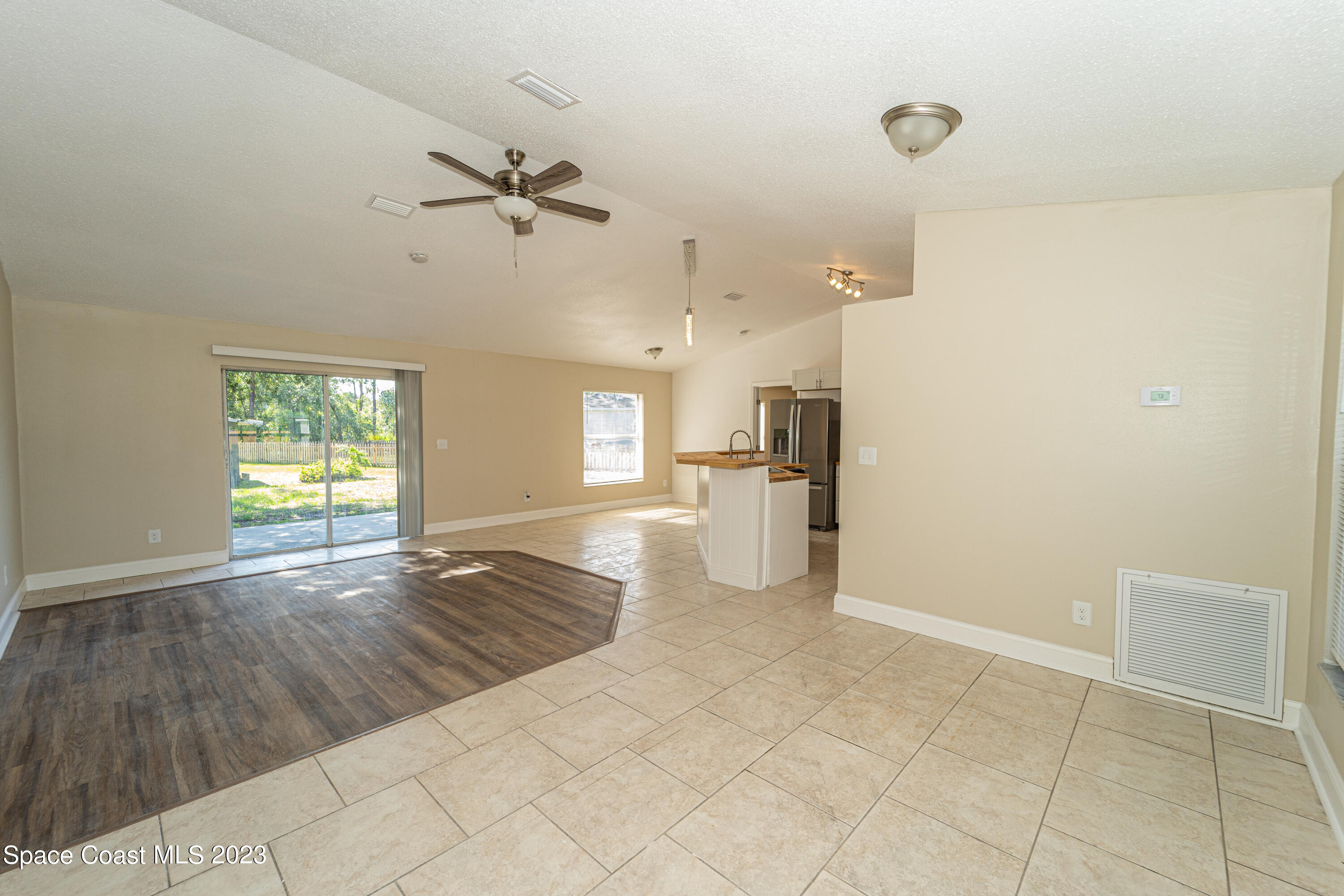215 Trilby Road Southwest Palm Bay, FL 32908 - Photo 3 of 19 a view of empty room with wooden floor and fan