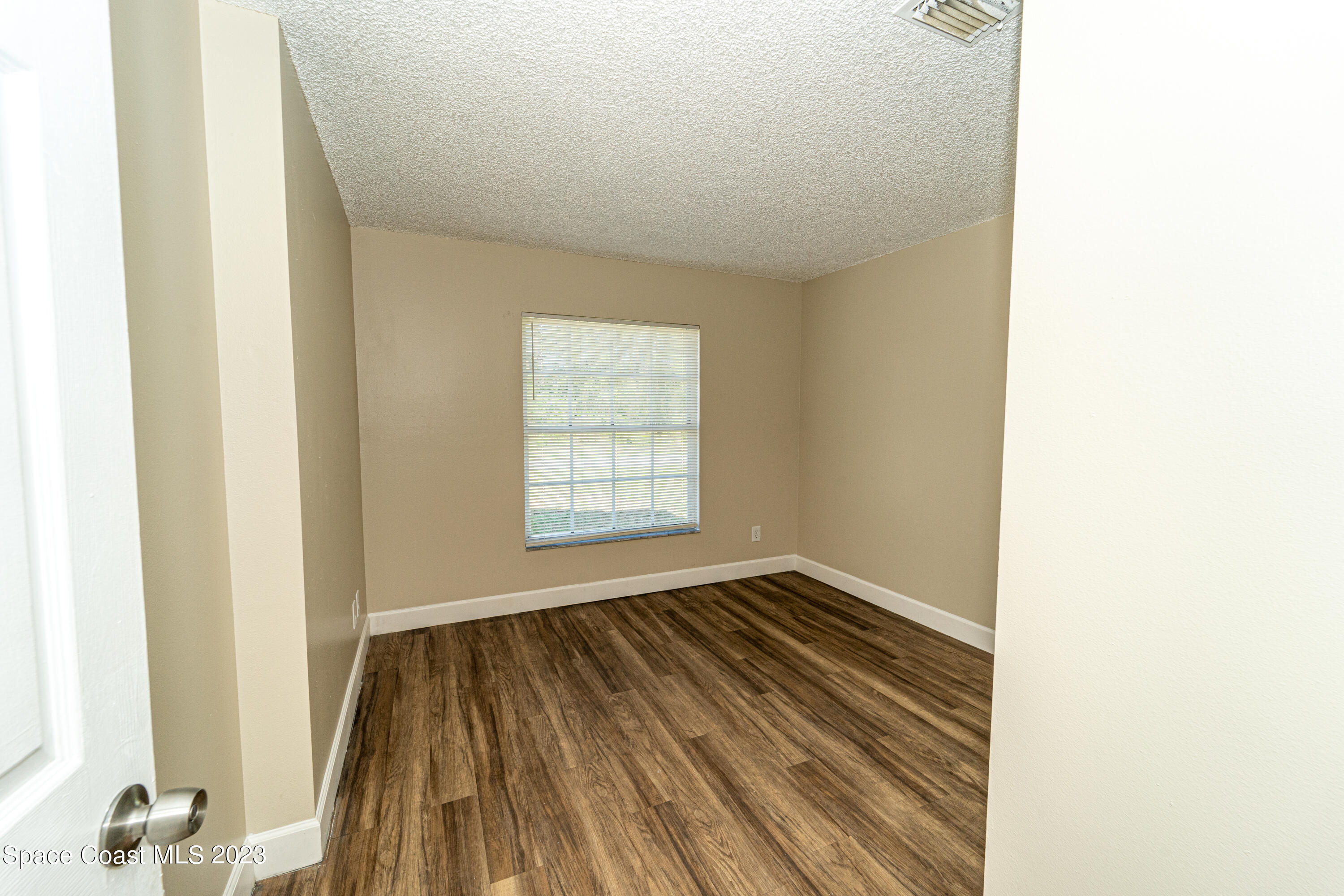 215 Trilby Road Southwest Palm Bay, FL 32908 - Photo 4 of 19 a view of a room with wooden floor and a window