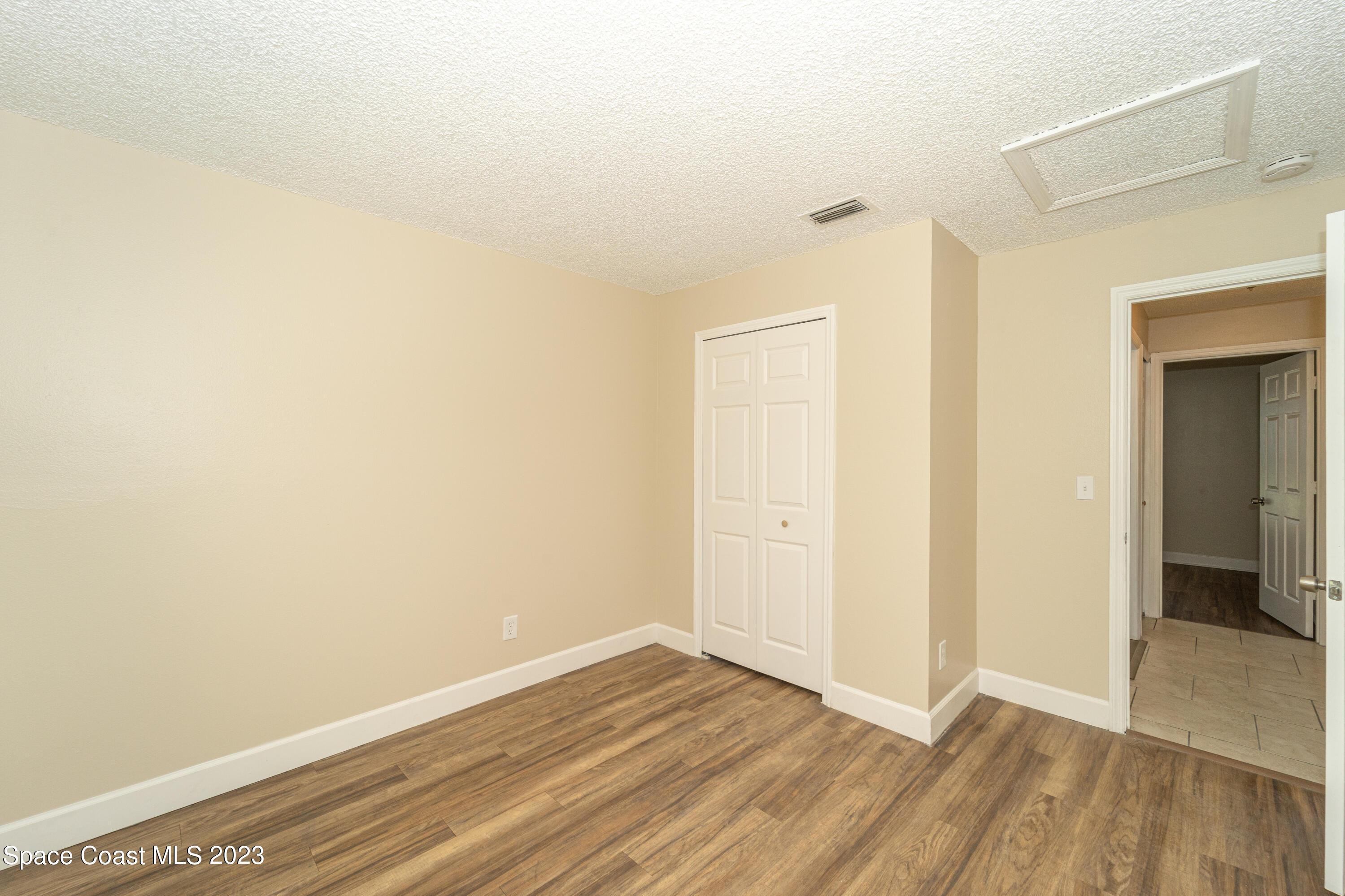 215 Trilby Road Southwest Palm Bay, FL 32908 - Photo 5 of 19 a view of an empty room with wooden floor
