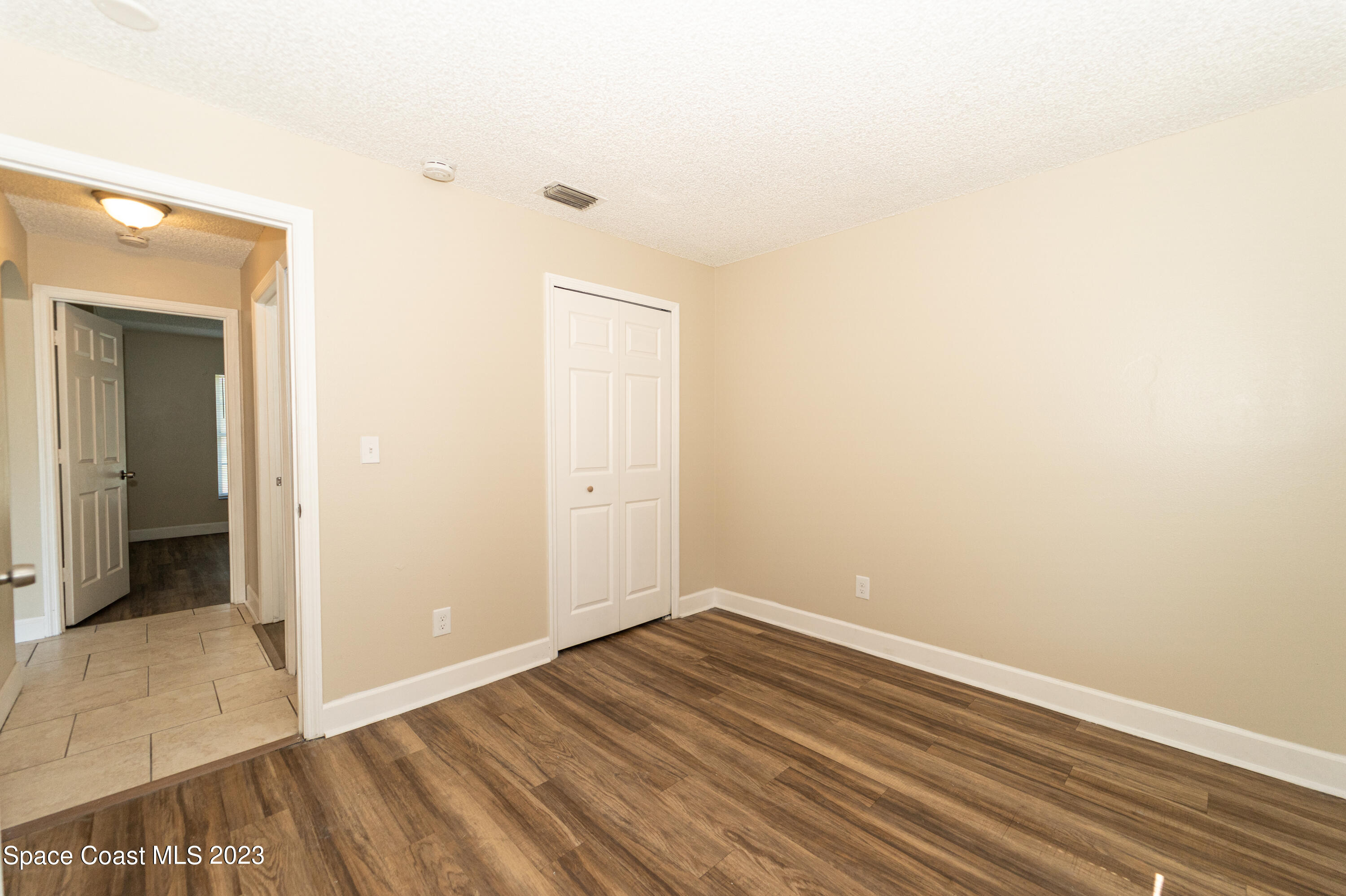 215 Trilby Road Southwest Palm Bay, FL 32908 - Photo 8 of 19 an empty room with wooden floor and closet