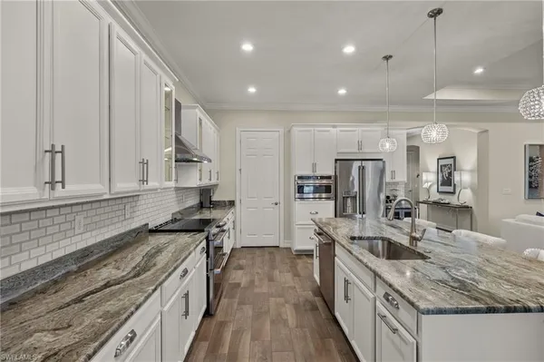 a kitchen with stainless steel appliances granite countertop a sink stove and refrigerator