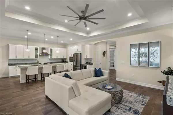 a living room with couches and kitchen view with wooden floor