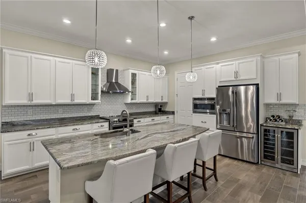 a kitchen with refrigerator a sink and chairs