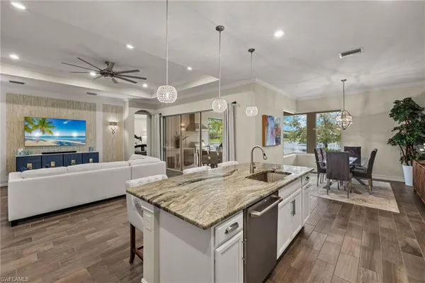 a kitchen with granite countertop counter space a sink appliances and a living room