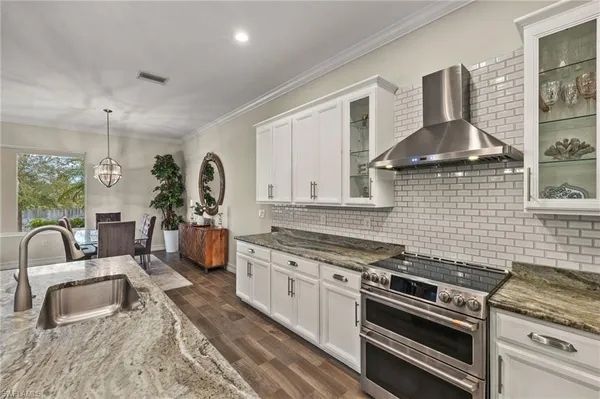 a kitchen with stainless steel appliances granite countertop a sink stove and cabinets