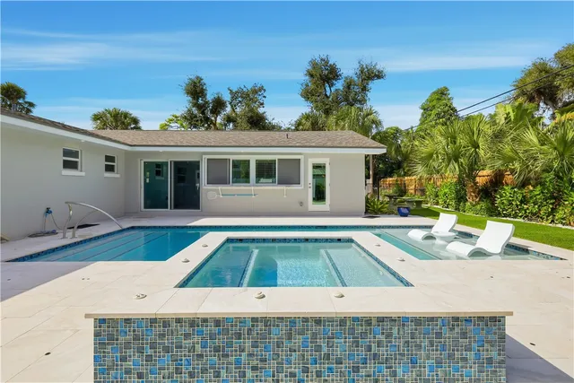 a white house with a yard and swimming pool in front of it
