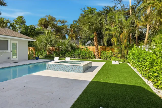 a view of yard with swimming pool and trees in the background