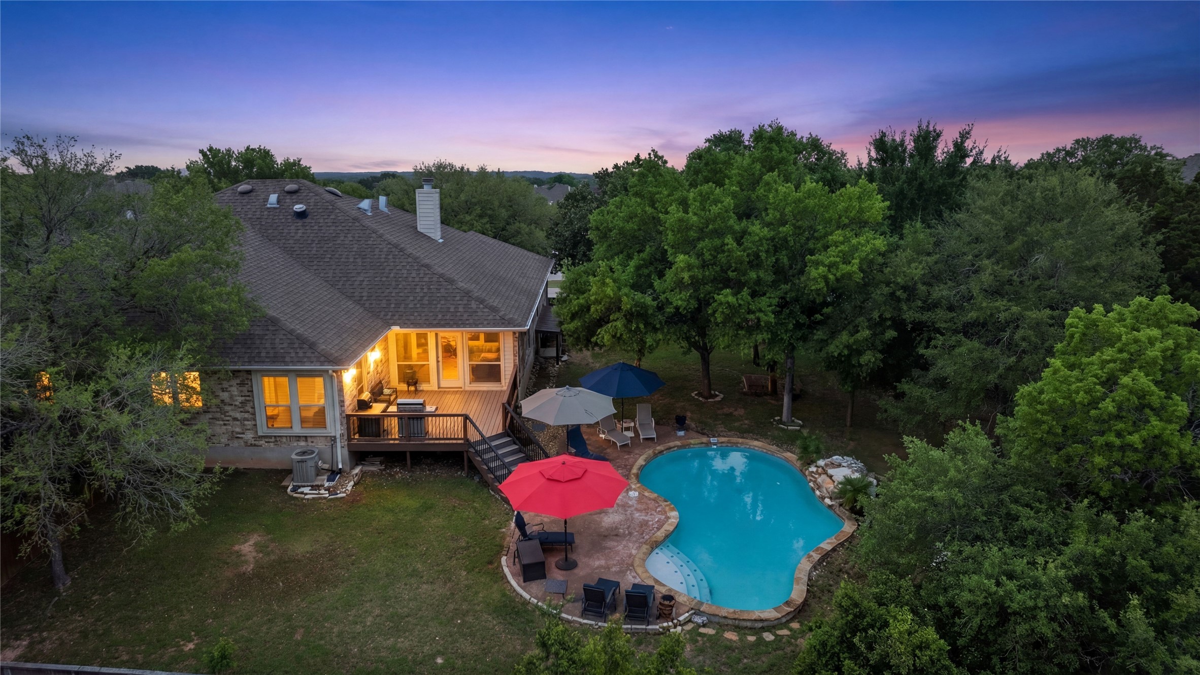 15208 Nightingale Lane Austin, TX 78734 - Photo 36 of 40 Back of property with an outdoor pool, a deck, a chimney, a patio, and view of scattered trees