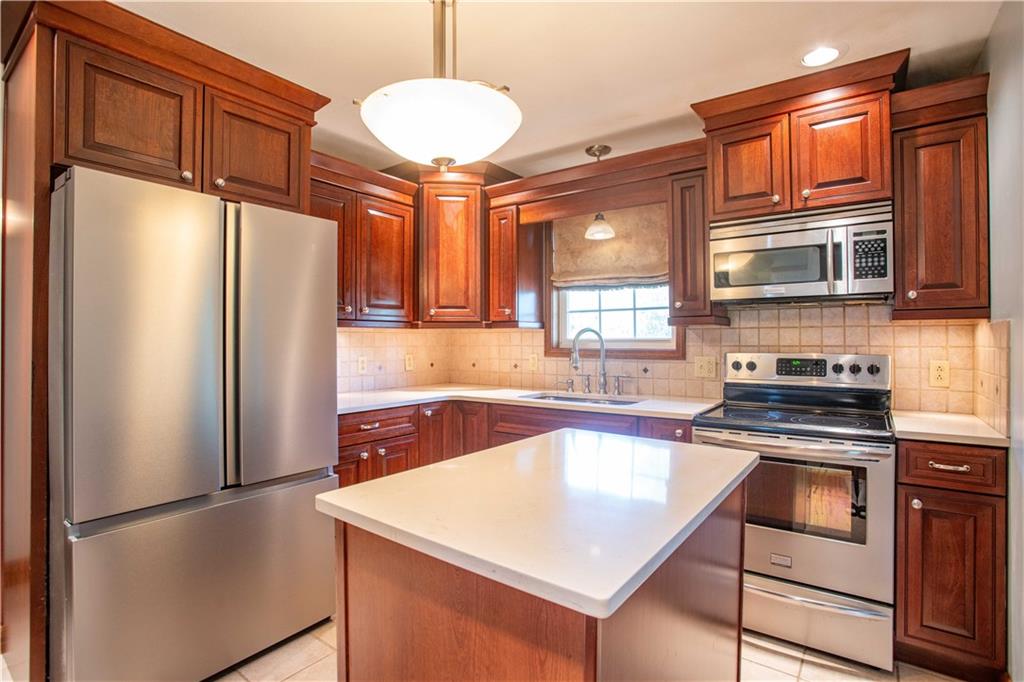 103 Mowry Road Monaca, PA 15061 - Photo 4 of 38 a kitchen with stainless steel appliances granite countertop a refrigerator a stove a sink and a microwave
