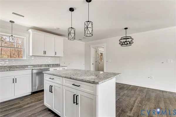 a kitchen with a counter top space cabinets and wooden floor
